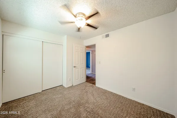 an empty room with a fan and a fan