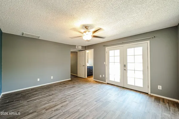 an empty room with wooden floor and windows