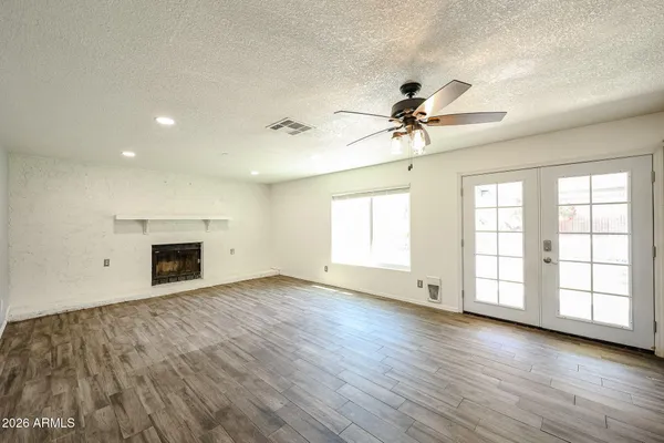 a view of an empty room with window and wooden floor