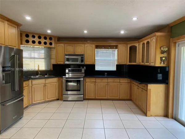 a kitchen with a refrigerator and a stove top oven