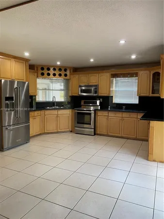 a kitchen with stainless steel appliances granite countertop a stove a sink and a refrigerator