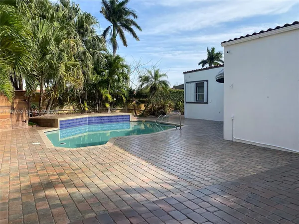 a view of a house with pool and a yard