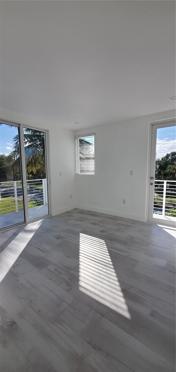 3787 Thomas, Unit 3787 Miami, FL 33133 - Photo 22 of 22 an empty room with wooden floor and windows