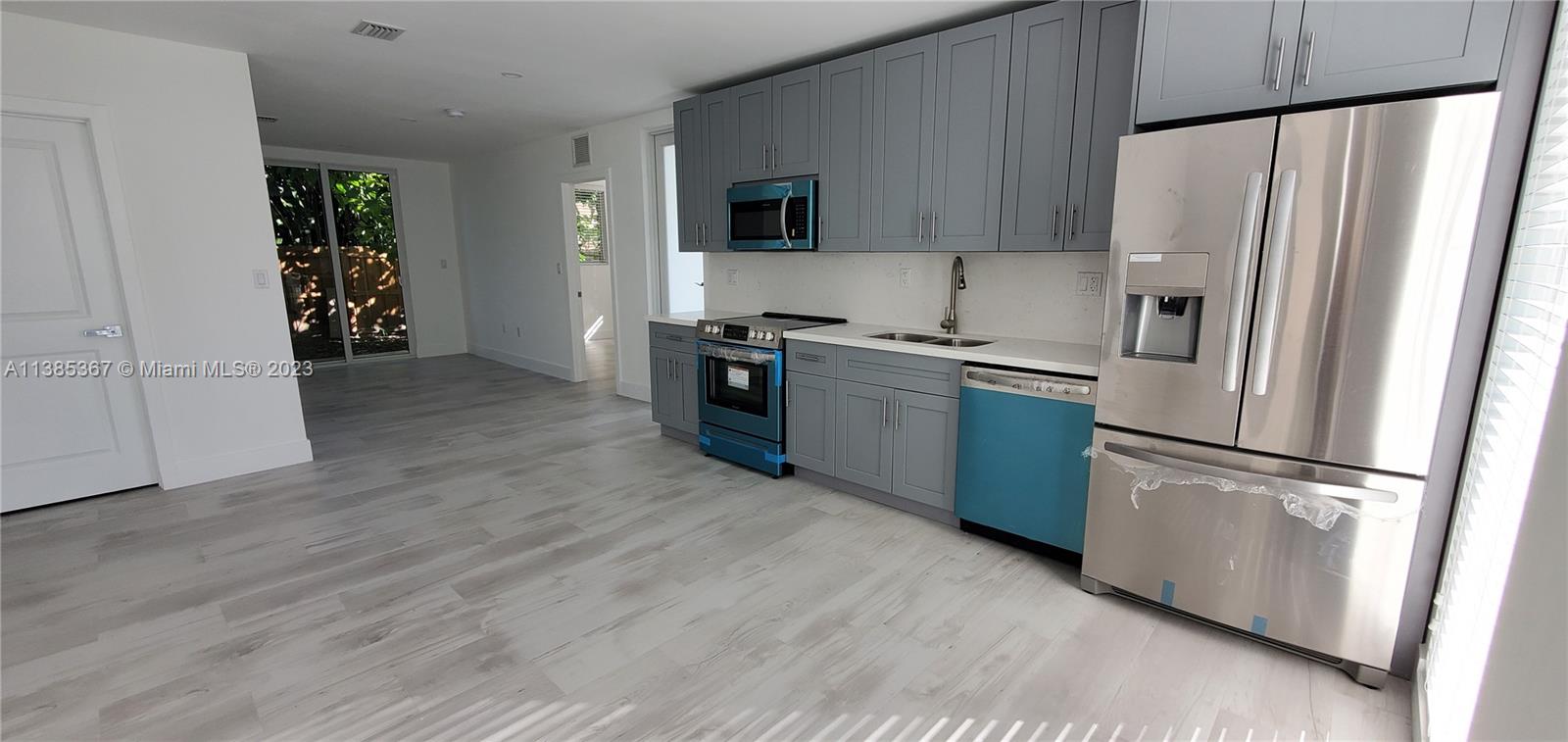 3787 Thomas, Unit 3787 Miami, FL 33133 - Photo 4 of 22 a kitchen with stainless steel appliances granite countertop a refrigerator microwave and stove
