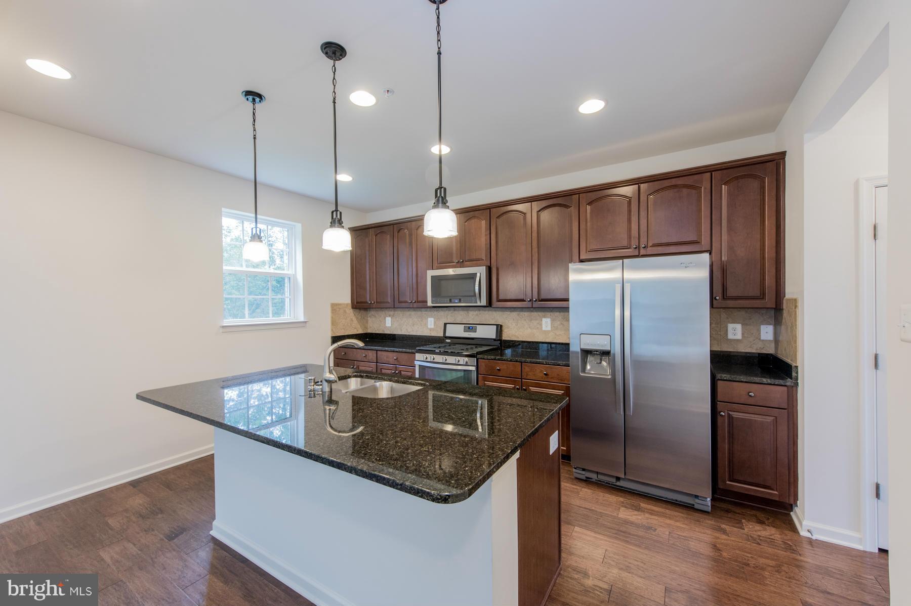 10515 Braddock Run Road Middle River, MD 21220 - Photo 7 of 27 a kitchen with stainless steel appliances granite countertop a sink a refrigerator and a granite counter tops