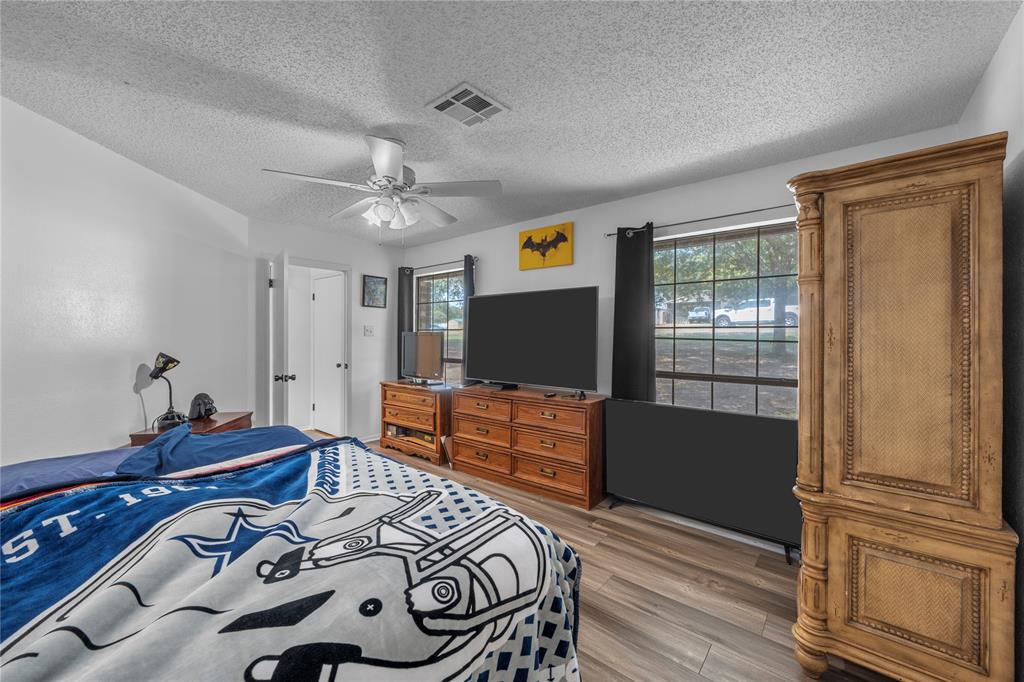 215 Lajuana Drive Waco, TX 76705 - Photo 23 of 33 Bedroom with a textured ceiling, light wood-type flooring, and ceiling fan
