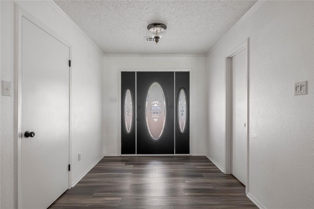 215 Lajuana Drive Waco, TX 76705 - Photo 4 of 33 Entryway with a textured ceiling, dark wood finished floors, a textured wall, and ornamental molding
