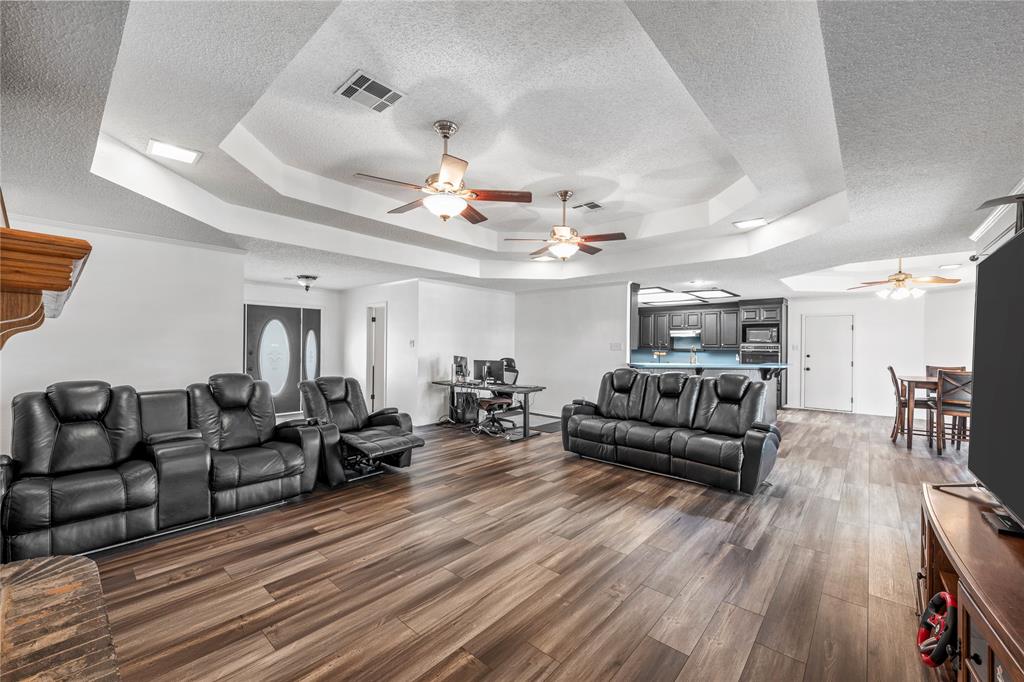 215 Lajuana Drive Waco, TX 76705 - Photo 7 of 33 Living area featuring a tray ceiling, ceiling fan, wood finished floors, and a textured ceiling