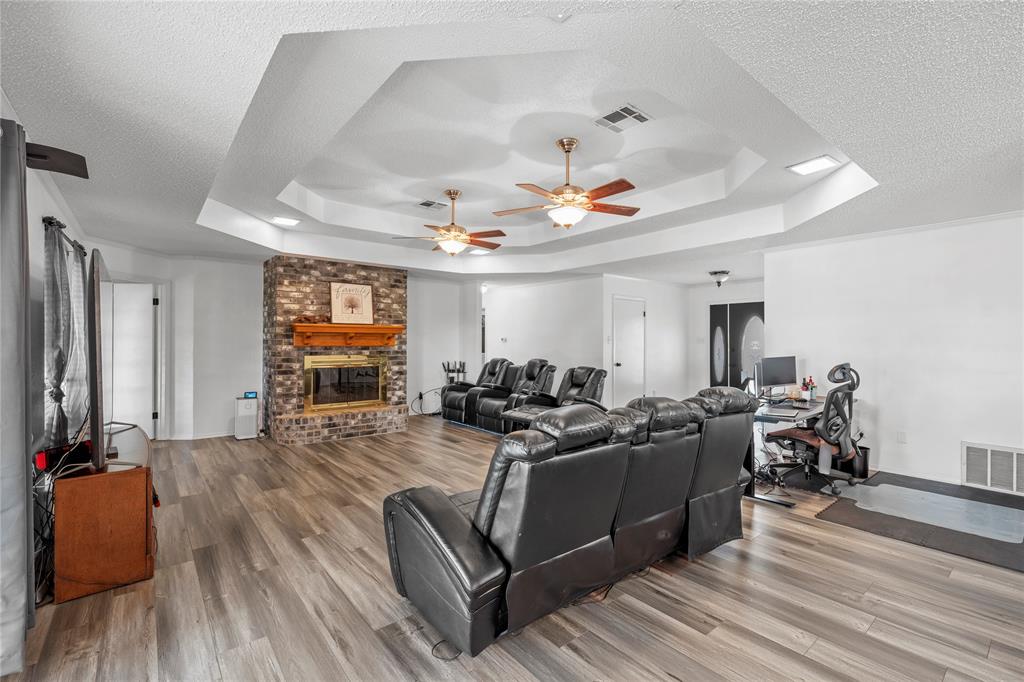 215 Lajuana Drive Waco, TX 76705 - Photo 8 of 33 Living area with a raised ceiling, light wood finished floors, a desk, a fireplace, and a textured ceiling