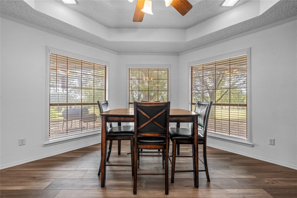 215 Lajuana Drive Waco, TX 76705 - Photo 9 of 33 Dining area featuring a raised ceiling, a textured ceiling, a ceiling fan, and dark wood finished floors