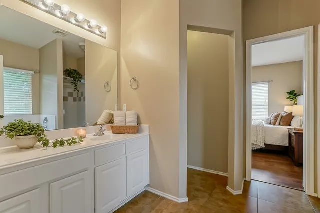 a en suite bathroom with a granite countertop sink and a mirror