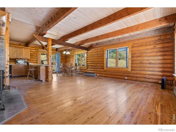 a kitchen with stainless steel appliances kitchen island granite countertop a table chairs in it and wooden floors