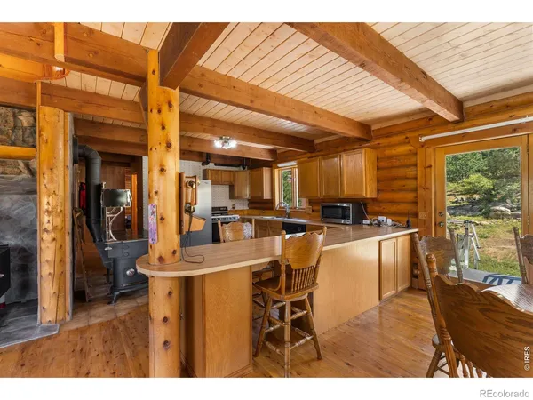 a dining room with wooden floor and large windows