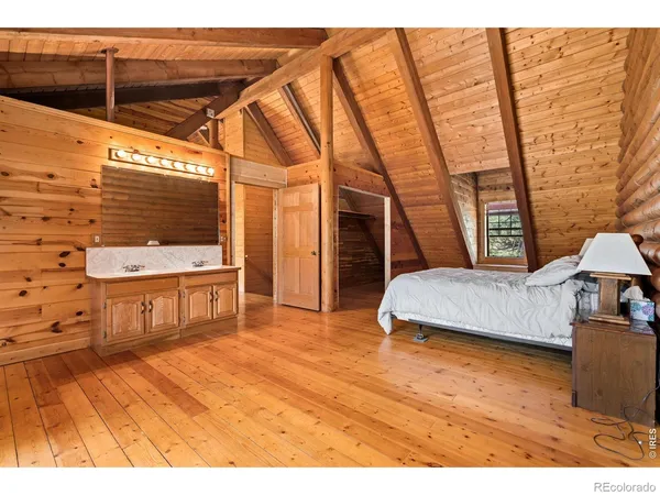 a bedroom with a bed and a wooden floor