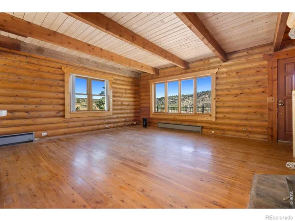 a view of empty room with wooden floor
