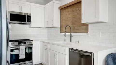 a kitchen with stainless steel appliances a stove sink microwave and cabinets