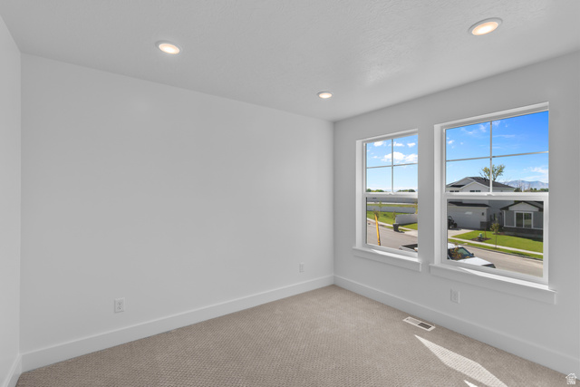 1213 West 500 South Logan, UT 84321 - Photo 20 of 29 Room featuring two large windows with grid muntins, recessed ceiling lighting, light-toned carpeting, and white baseboards