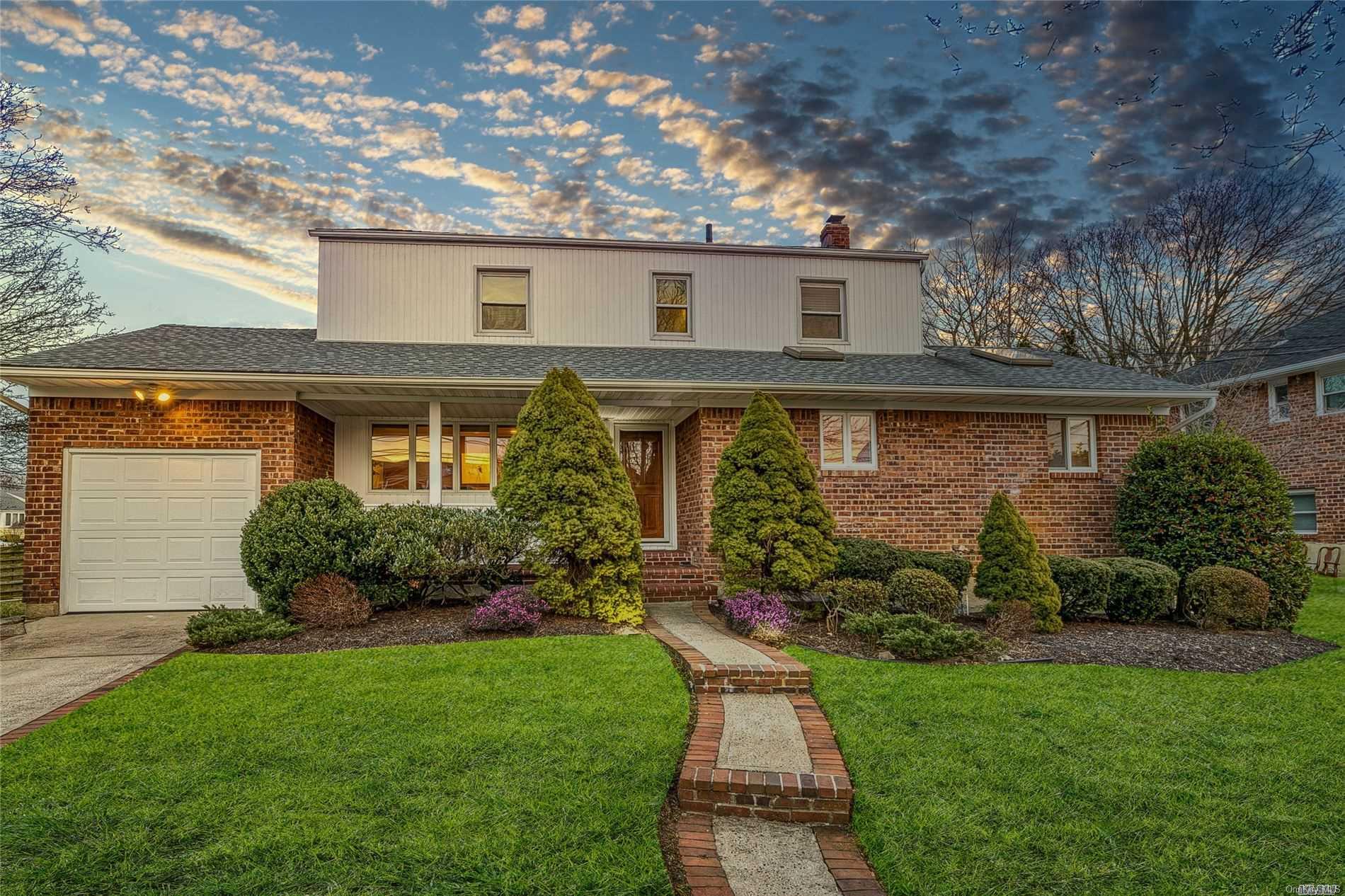 a front view of a house with a yard and outdoor seating