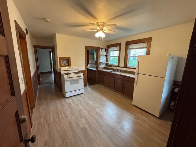 a kitchen with stainless steel appliances granite countertop a refrigerator a stove a sink a washer dryer and white cabinets