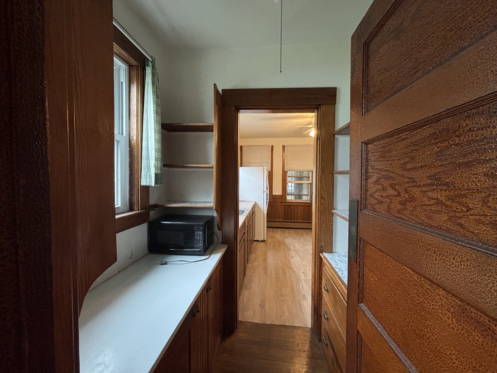 49 Clark Street, Unit 1 Framingham, MA 01702 - Photo 4 of 7 a hallway with a large mirror and a wooden floor