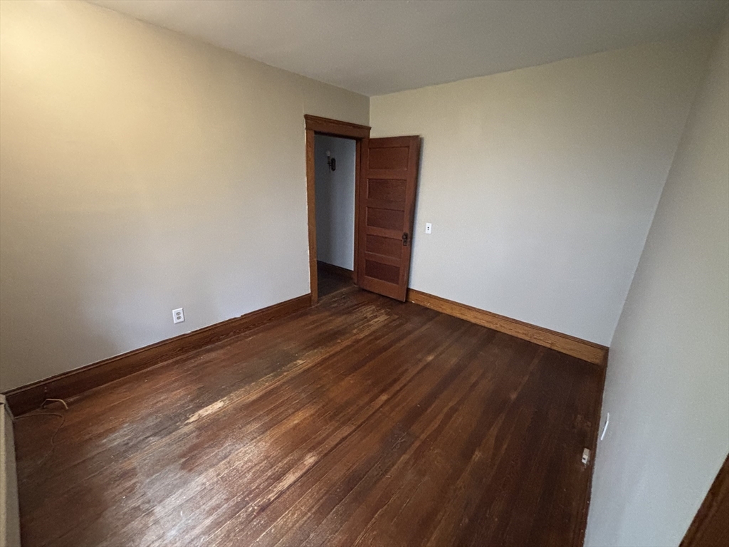 49 Clark Street, Unit 1 Framingham, MA 01702 - Photo 5 of 7 a view of an empty room with wooden floor