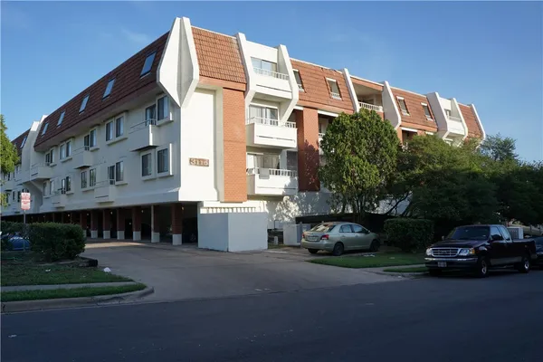 a car parked in front of a white building