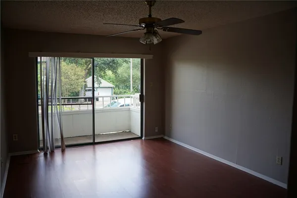 a view of a livingroom with wooden floor and a ceiling fan
