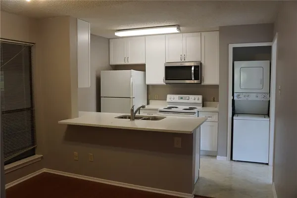 a kitchen with kitchen island a sink appliances and cabinets