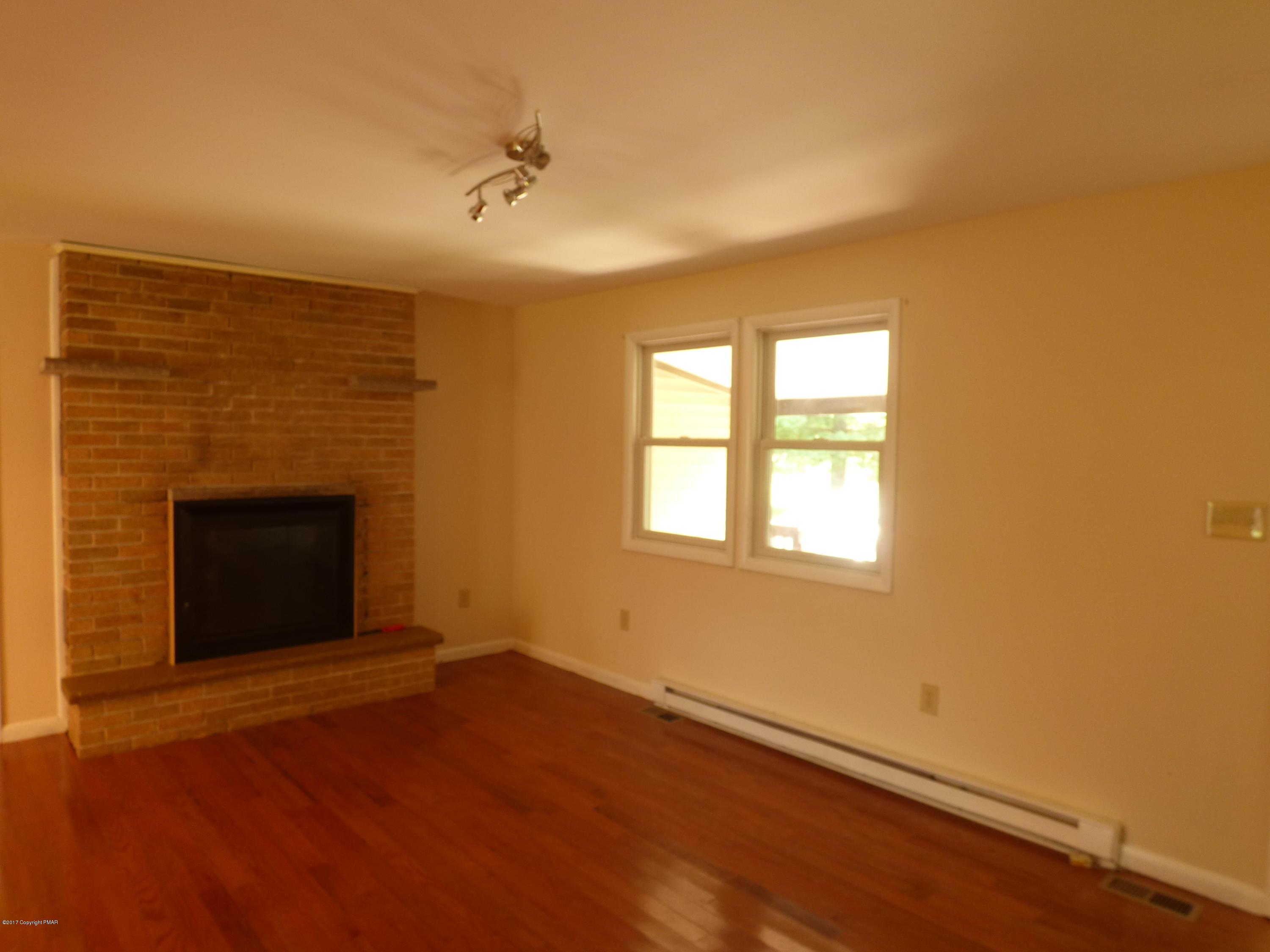 1178 Mattioli Road Bartonsville, PA 18321 - Photo 10 of 21 a view of an empty room with a fireplace and a window