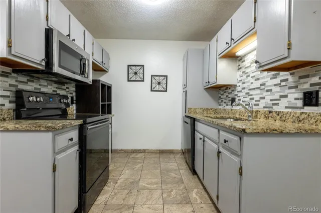 a kitchen with stainless steel appliances granite countertop a sink and a stove
