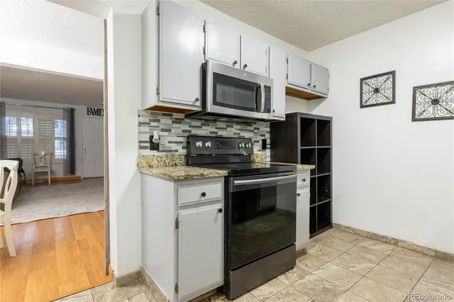 a kitchen with stainless steel appliances granite countertop a stove a microwave and a refrigerator