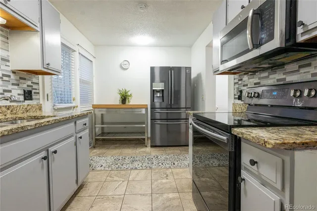 a kitchen with a stove a refrigerator and a sink