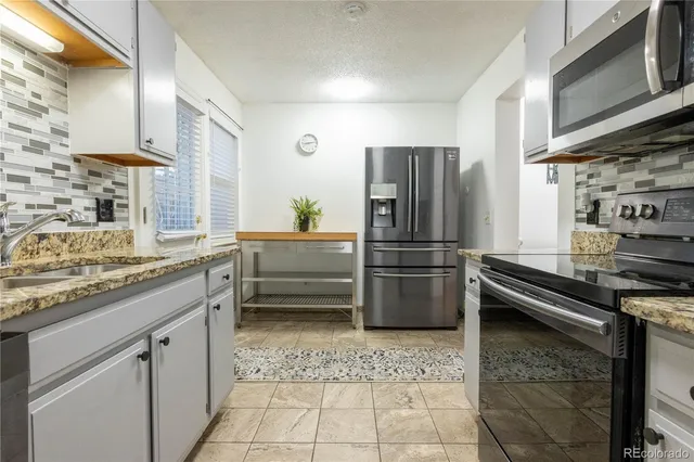 a kitchen with a refrigerator sink and stove