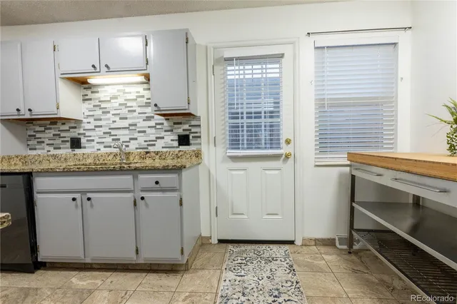 a kitchen with granite countertop white cabinets and white appliances