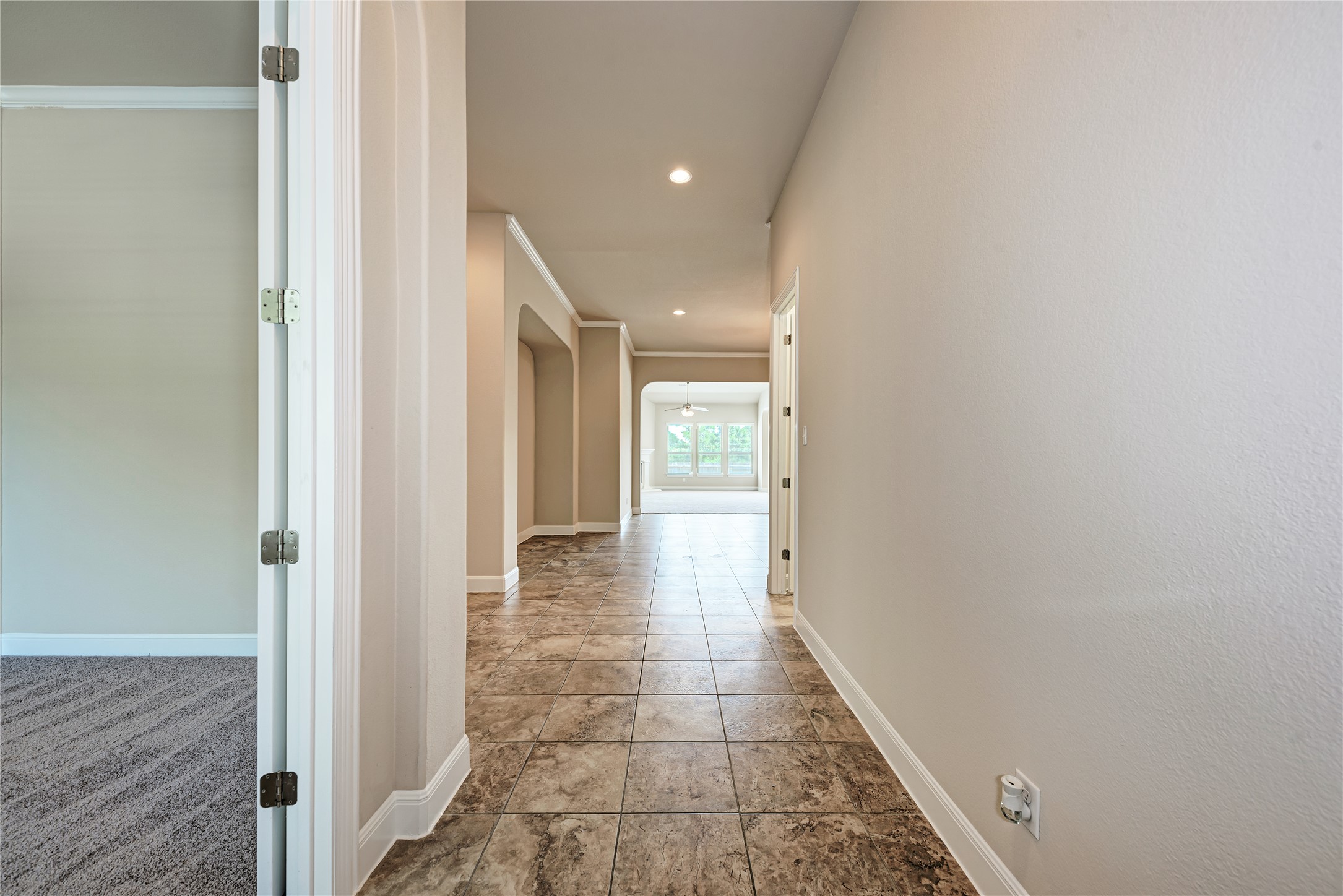600 Rosedale Boulevard Georgetown, TX 78628 - Photo 6 of 28 A lengthy, tile-floored hallway leads to an inviting living area with a cooling ceiling fan.