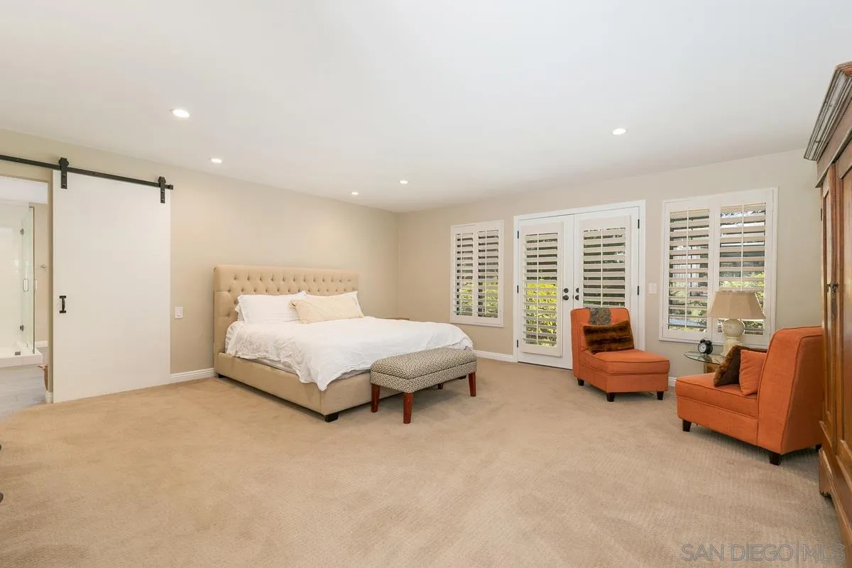 1122 Rancho Encinitas Drive Encinitas, CA 92024 - Photo 17 of 39 a spacious bedroom with a bed and glass window