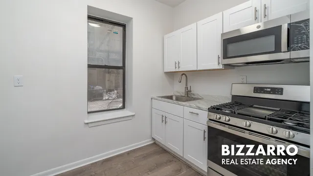 a kitchen with stainless steel appliances granite countertop a refrigerator a stove a sink and a microwave