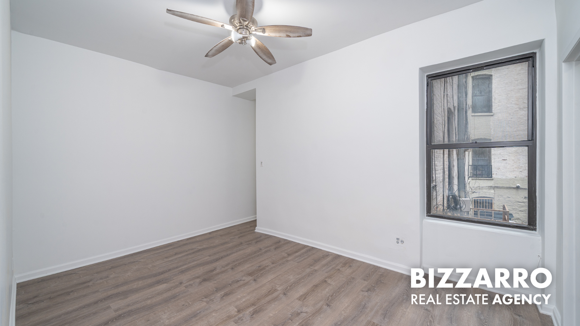 Undisclosed Address Manhattan, NY 10031 - Photo 2 of 20 an empty room with wooden floor chandelier fan and windows
