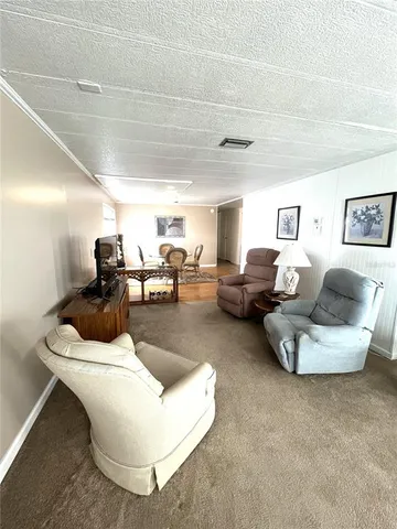 a living room with furniture gym equipment and large windows