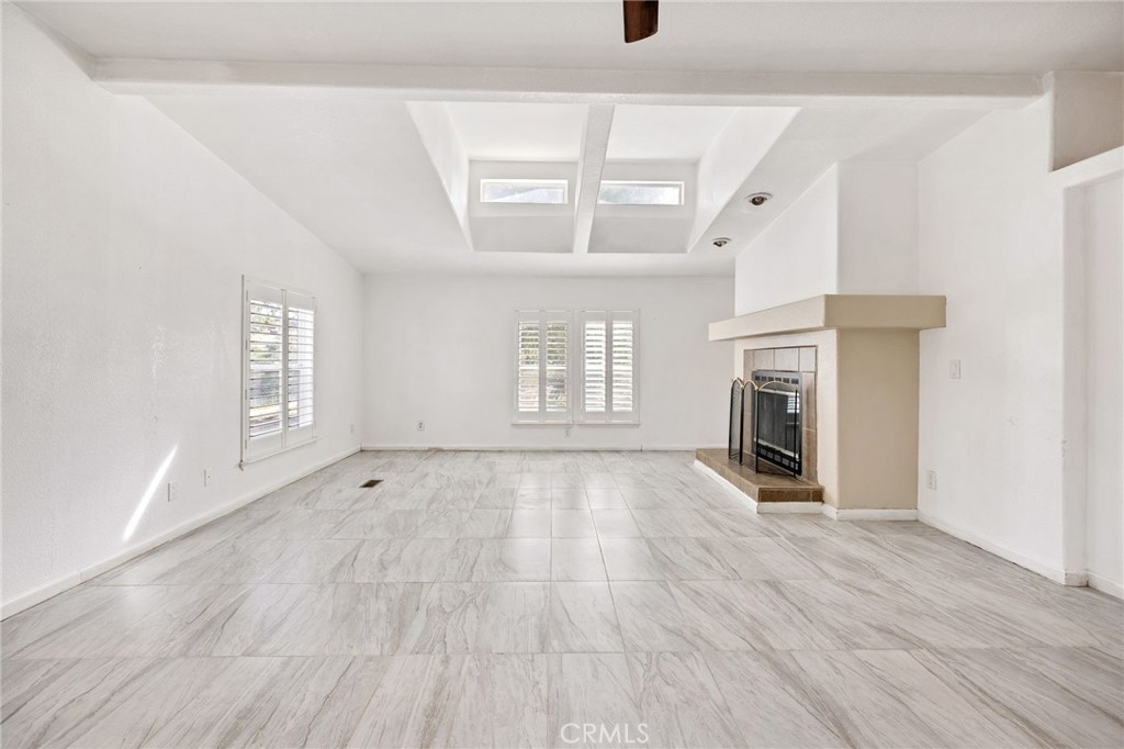 43870 Wilson Valley Road Hemet, CA 92544 - Photo 5 of 35 an empty room with wooden floor a fireplace and windows