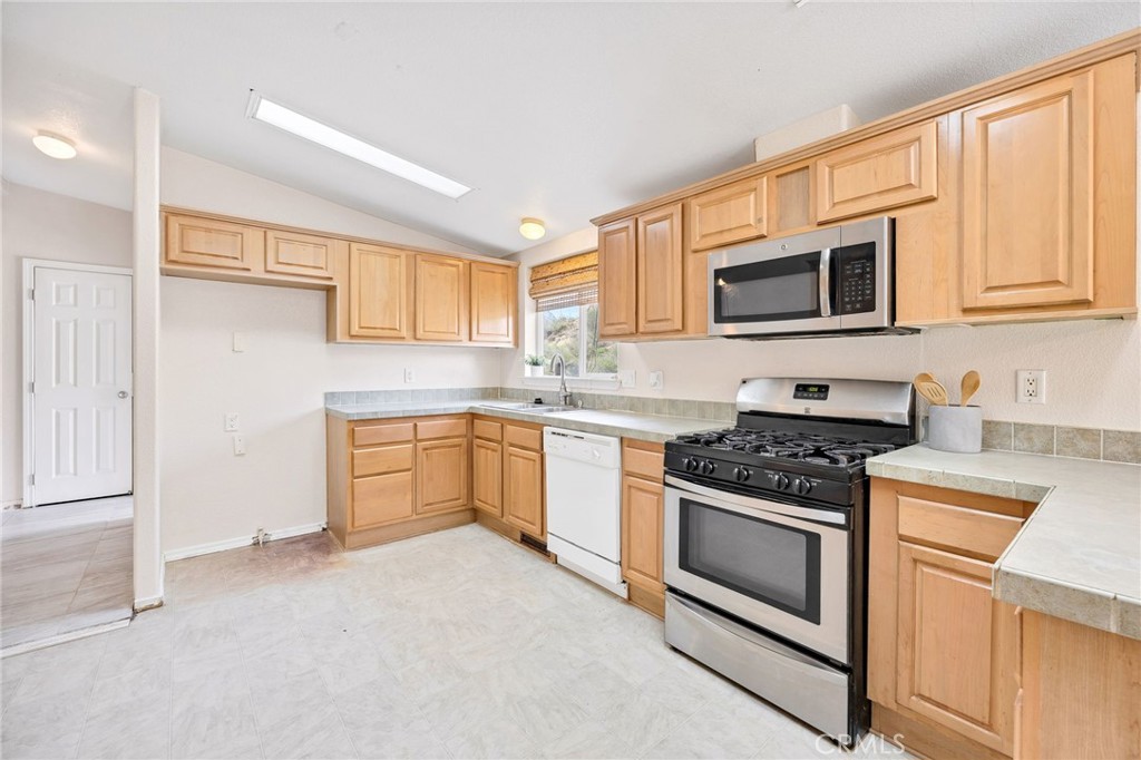 43870 Wilson Valley Road Hemet, CA 92544 - Photo 8 of 35 a kitchen with stainless steel appliances granite countertop white cabinets a sink a stove a microwave and a refrigerator