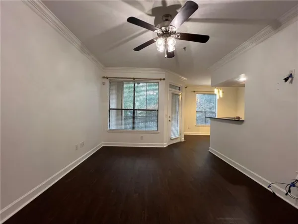 an empty room with wooden floor and windows