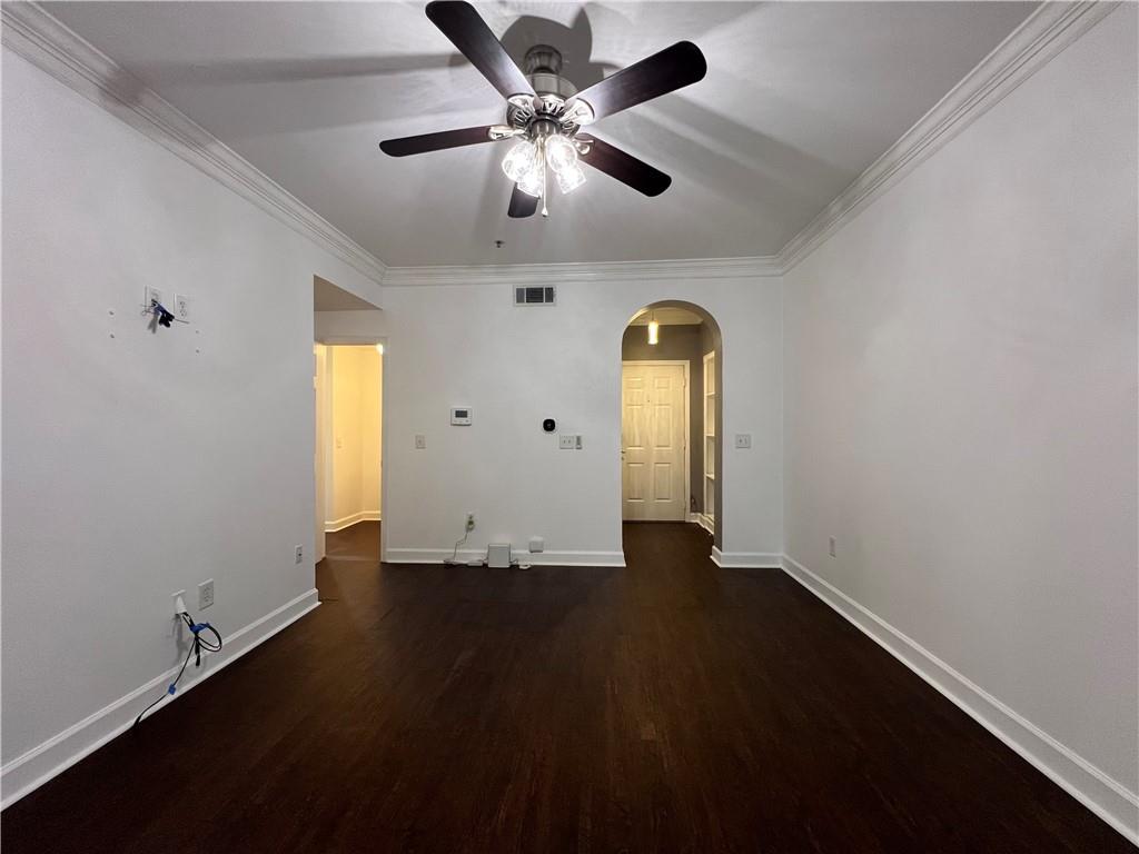3777 Peachtree Road Northeast, Unit 1116 Brookhaven, GA 30319 - Photo 5 of 28 an empty room with wooden floor chandelier fan and windows