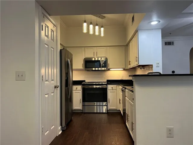 a kitchen with stainless steel appliances granite countertop a stove a sink and a refrigerator