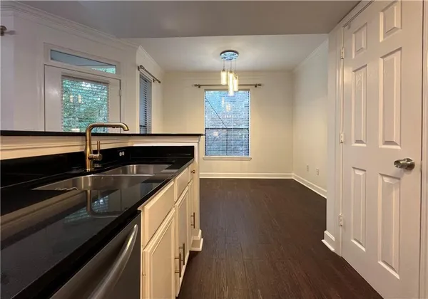 a kitchen with granite countertop a sink and wooden floor