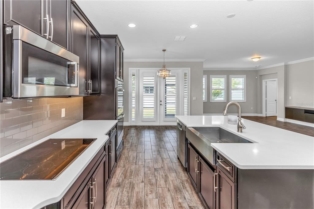 1270 Turnbridge Place Oviedo, FL 32765 - Photo 11 of 14 a kitchen with counter top a sink and wooden floors