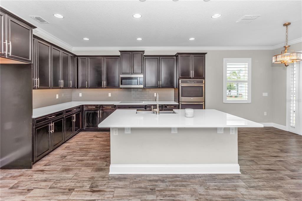 1270 Turnbridge Place Oviedo, FL 32765 - Photo 10 of 14 a large kitchen with stainless steel appliances a large counter top a stove a refrigerator and a sink