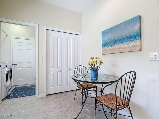 a kitchen with a dining table chairs and refrigerator