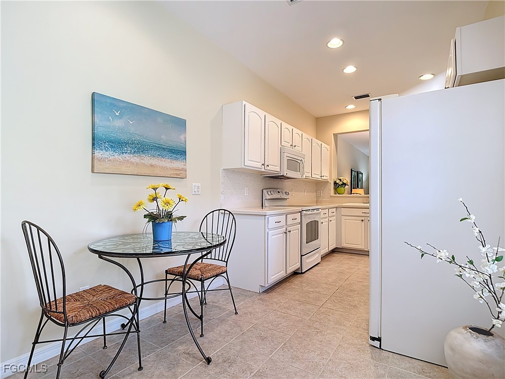 3600 Rue Alec Loop, Unit 4 North Fort Myers, FL 33917 - Photo 10 of 43 a kitchen with a dining table chairs and refrigerator