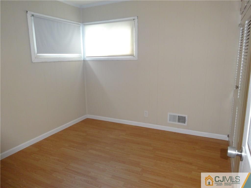 25 Sturgis Road Edison, NJ 08817 - Photo 6 of 8 a view of an empty room with wooden floor and a window